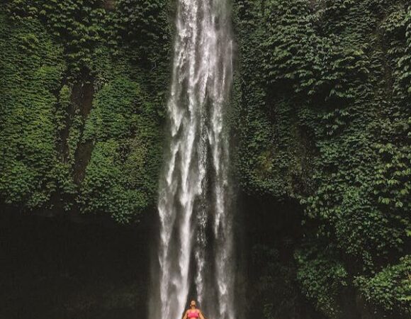 Bali Women Trip - Woman enjoying a refreshing dip at a pristine Bali waterfall